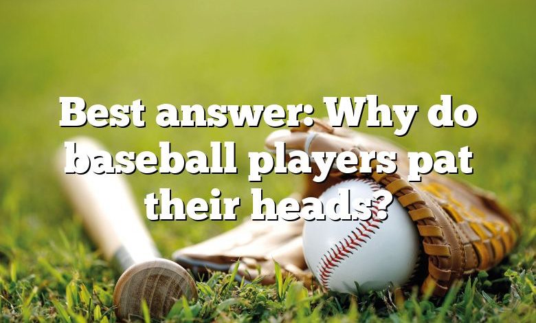 Best answer: Why do baseball players pat their heads?