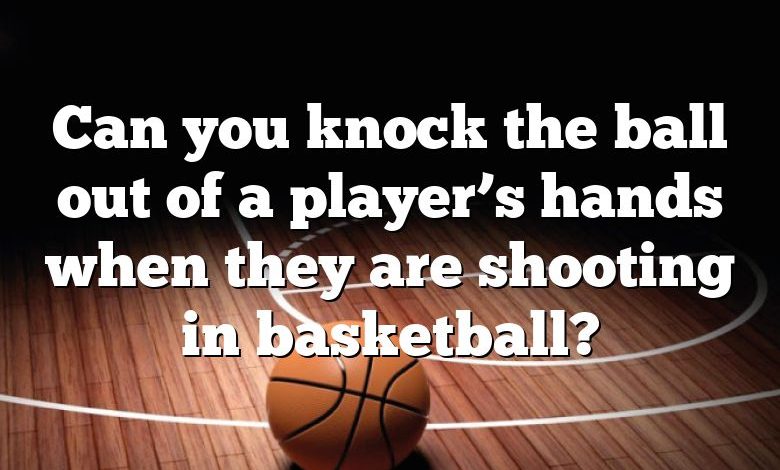 Can you knock the ball out of a player’s hands when they are shooting in basketball?