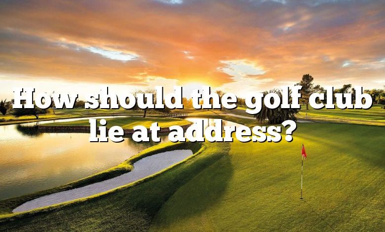 How should the golf club lie at address?