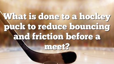 What is done to a hockey puck to reduce bouncing and friction before a meet?